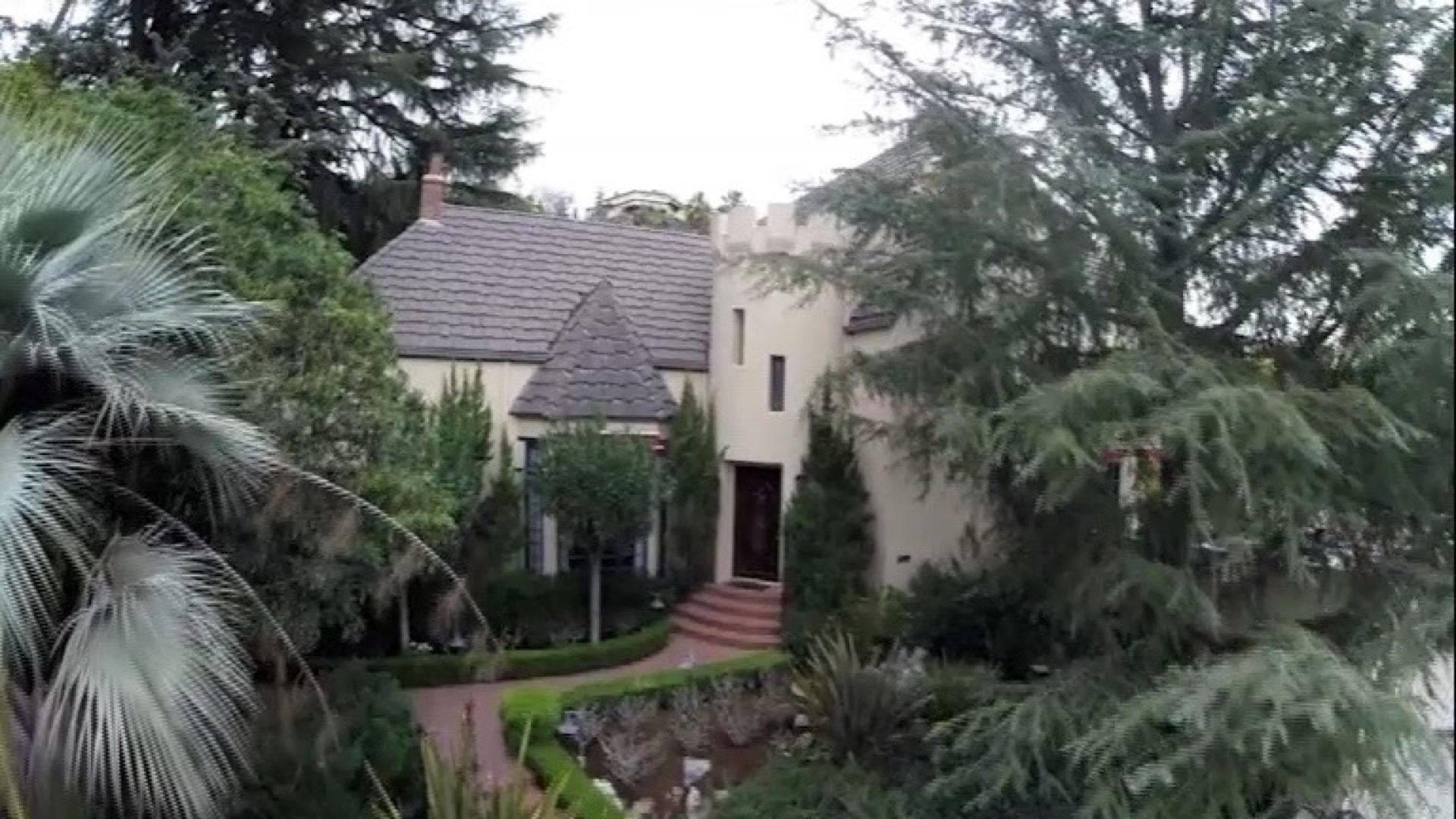 French Country front elevation framed by mature landscaping